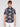 A young man with light brown hair wears the Projek Raw BENJAMIN-BLACK short-sleeve palm tree print shirt in wrinkle-resistant fabric and white pants, standing against a plain light gray background.