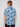 A person with light brown hair is seen from behind, wearing the BENJAMIN-BLUE palm tree print shirt by Projek Raw, in a light blue, wrinkle-resistant fabric, standing against a plain light background.