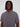 A man with medium-length dreadlocks wears the Projek Raw ALEXANDER-GREY short-sleeve 4-way stretch travel shirt with a zippered chest pocket, standing against a plain light background.