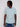 A man wears a Projek Raw BLAISE-AQUA modern casual cotton short-sleeve shirt with two chest pockets and blue jeans, standing against a plain white background and looking to his left.