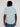 A person with medium-dark skin and shoulder-length dreadlocks is seen from behind, wearing the Projek Raw BLAISE-AQUA modern casual mens striped shirt in light blue with thin white stripes and blue jeans against a plain background.