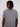 A man with medium-length dreadlocks, wearing the Projek Raw BLAISE-BLACK cotton short-sleeve shirt with two front pockets, looks to his left against a plain white background.