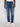 Wearing Projek Raw’s NOLAN-INDIGO BLAST jeans with a white t-shirt and white sneakers, the person stands against a plain light background, arms relaxed by their sides.