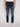 A person wearing Projek Raw KEVIN-INK BLUE denim pants with a white shirt and sneakers stands against a plain light background, visible only from the lower torso to the legs.