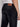 A person is shown from the waist down, facing away, wearing a white shirt and Projek Raw HENRI-BLUE BLACK RINSE regular-fit jeans with brown stitching, back pockets, and a brown leather patch on the waistband.