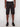 A person wears Projek Raw’s EDGAR-BLACK cargo shorts, paired with a white T-shirt and black sneakers, standing against a plain light background. The photo is cropped from shoulders to feet, highlighting the shorts.