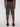 A person wearing the Projek Raw EDGAR-OLIVE knee-length cargo shorts and black shoes stands facing away, highlighting the shorts dark olive color, visible seams, and two buttoned back pockets.