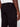A close-up of a persons lower back and hand wearing Projek Raws NATHANIAL-BLACK pants with visible stitching, a patch pocket, and zipper detail, paired with a white shirt.