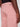 A person wearing Projek Raw NATHANIAL-ROSE light pink pants, shown from the waist down with their hand beside their hip. The pants feature visible stitching and back pockets.