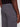 A close-up of a person wearing Projek Raw’s ISMAËL-GREY cargo pants and a black shirt, highlighting the back pocket, waistband, detailed stitching, and signature label.