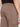 A close-up of a person wearing Projek Raws PAULIN-CASHEW light brown cargo pants, featuring a back pocket, side flap pocket, and elastic waistband, standing with their back to the camera.