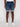 A person wearing the Projek Raw KAEL-DARK BLUE denim shorts with rolled cuffs, paired with a white t-shirt and white sneakers, stands against a plain light background. The photo is cropped from the shoulders down.