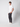 A young man stands against a plain light background, hands in his pockets, wearing a white T-shirt, PROJEK RAW Men’s Stretch Bungee Cargo Jogger in a relaxed fit, and white sneakers, looking slightly to the side.