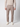 A person models the PROJEK RAW Men’s Plaid Bungee Drawstring Pant in light brown plaid with a beige sweater and white sneakers, standing against a plain light grey background. Only the body from the shoulders down is shown.