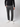 A person in a black long-sleeve shirt, PROJEK RAW Mens Brushed Bungee Drawstring Pant, and white sneakers stands with one hand in their pocket against a plain light background.