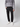 A person wears a gray textured sweater, PROJEK RAW Men’s Canvas Bungee Pull-on Cargo Jogger with pockets in black, and white sneakers. Standing against a plain light background, their hands are in their pockets and their head is not visible.