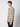 A young man with curly hair wears the PROJEK RAW Mens Long Sleeve Plaid Button-up Shirt in light brown and beige, standing sideways and looking at the camera against a plain light gray background.
