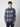 A young man with short, curly brown hair wears the PROJEK RAW Mens Long Sleeve Plaid Button-up Shirt in blue and gray with dark pants, standing against a light background and looking directly at the camera with a neutral expression.