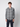 A young man with short curly hair models the PROJEK RAW Mens Long Sleeve Plaid Button-up Shirt with a chest pocket, standing facing forward against a plain light gray background to highlight its classic casual style.