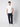A young man stands against a plain white background, wearing a PROJEK RAW Mens Liquid Cotton Short Sleeve T-shirt, dark blue pants, and white sneakers, with one hand in his pocket.