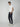 A man stands sideways with one hand in his pocket, wearing a fitted white T-shirt, PROJEK RAW Mens Solid Bungee Jogger pants, and off-white sneakers against a plain light gray background.