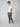 A man models PROJEK RAW Mens Solid Bungee Cargo Jogger pants with an elastic waistband, paired with a white t-shirt and sneakers. He stands in a studio, one hand in his pocket, looking at the camera against a plain light background.