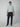A young man stands facing forward against a plain light gray background, wearing a light blue short-sleeve T-shirt, PROJEK RAW Mens Bungee Loose Cargo Pant, and navy slip-on shoes.