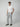 A man stands against a gray background wearing a white short-sleeve t-shirt, PROJEK RAW Mens Drawstring Chino Pant for comfortable everyday wear, and black slip-on shoes.