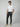 A man stands against a gray background wearing a white tee, PROJEK RAW Men’s Bungee Chino Pant in dark slim fit, and beige slip-on shoes with his left hand in his pocket—showcasing effortless, versatile style.