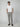 A man stands against a plain light gray background, wearing a white short-sleeve t-shirt, dark brown loafers, and PROJEK RAW Mens Bungee Plaid Drawstring Chino Pant. His hands are in his pockets and he looks straight ahead.