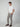 A man with short, curly brown hair stands against a plain background, hands in his pockets, wearing a white T-shirt and PROJEK RAW Mens Bungee Plaid Drawstring Chino Pant. He completes the look with brown loafers.