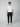 A young man stands against a plain light background, wearing a white short-sleeve shirt with a small logo, PROJEK RAW MENS CARGO PULL-ON JOGGER in navy with drawstring, and crisp white sneakers.