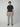 A young man with brown hair stands against a gray background, wearing a navy t-shirt, brown sandals, and PROJEK RAW Mens Drawstring Linen Pant. He faces forward with a neutral expression.