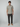 A man stands facing forward against a plain light gray background, wearing the PROJEK RAW Mens Short Sleeve Textured 4-Way Stretch Shirt with dark pants and tan suede shoes.