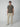 A man faces forward against a plain light background, wearing the PROJEK RAW Mens Short Sleeve Textured 4-Way Stretch Stripe Shirt in gray, paired with light beige cargo pants and white sneakers with dark accents.