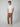 A man stands against a plain light background wearing PROJEK RAW Mens 5-Pocket Regular Fit Denim, a white short-sleeve t-shirt, and off-white sneakers, hands in his pockets with a neutral expression.