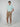 A young man stands against a plain backdrop, wearing PROJEK RAW Mens Chino Solid Bungee Shorts, a light blue t-shirt, and white sneakers. He has one hand in his pocket and looks directly at the camera with a neutral expression.