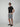 A man in sunglasses, a black t-shirt, and PROJEK RAW Mens Texture Bungee Pull-on Short with black slip-on shoes stands with one hand in his pocket against a light gray background.