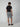 A man wearing a black t-shirt, PROJEK RAW Mens Texture Bungee Pull-on Short, and black shoes is standing with his back to the camera against a plain light background.