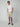 A man stands against a plain background wearing sunglasses, a white t-shirt, brown sandals, and PROJEK RAW MENS CARGO SHORT with his hands in his pockets—an essential summer staple.
