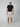 A man faces forward in a black tee, PROJEK RAW MENS CHINO SHORT in beige, matching sneakers, and a beige baseball cap, set against a plain light gray background.