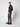 A man stands relaxed against a plain light background, wearing a dark long-sleeve sweater and PROJEK RAW Mens Stretch Bungee Cargo Pant, with one hand in his pocket and looking slightly to the side.