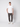 A man stands against a plain light background, wearing a white short-sleeve t-shirt, PROJEK RAW Men’s Stretch Bungee Cargo Jogger in dark gray, and white sneakers. He has one hand in his pocket and a neutral expression.