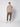 A young man stands against a light gray background, wearing a beige short-sleeve t-shirt, PROJEK RAW Men’s Canvas Bungee Pull-on Cargo Jogger in olive green, and white sneakers. One hand is in his pocket as he looks straight ahead.