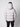A man is seen from the back wearing the PROJEK RAW Mens Quilted Ecofill Puffer with hood in light gray, paired with black pants, standing against a plain white background—an ideal look for cold weather.