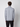 A person with short curly hair faces away from the camera, wearing a PROJEK RAW Mens Long Sleeve Full Zip Mock Neck Sweater in light gray and black pants, set against a plain white background.