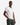 A man stands with one hand in his pocket, wearing the PROJEK RAW V-NECK PIMA COTTON T-SHIRT and dark green pants, looking confidently at the camera against a plain white background—a perfect example of a minimalist silhouette.