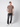 A young man stands against a plain light background, wearing the PROJEK RAW Mens Liquid Cotton Short Sleeve T-shirt in brown, paired with black jeans and white sneakers. One hand is in his pocket as he looks at the camera with a neutral expression.