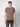A young man with light brown hair stands against a plain light gray background, wearing the PROJEK RAW Mens Liquid Cotton Short Sleeve T-shirt and dark jeans, looking directly at the camera with a neutral expression.