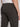 A close-up of a person in Projek Raw’s STEPHANE-OLIVE cargo pants, crafted from durable bungee fabric with rear and side cargo pockets. The wearer stands sideways with their right arm relaxed.